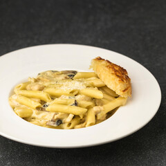 Alfredo pasta served in dish isolated on table top view of fastfood