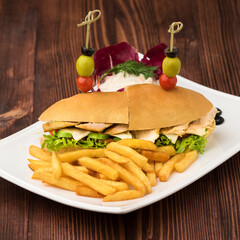California chicken sandwich with french fries served in dish isolated on table top view of fastfood