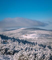 Beautiful sunny scenery of first snow in the mountains. View at the cabin in snow and forest. Shot right after snowing.