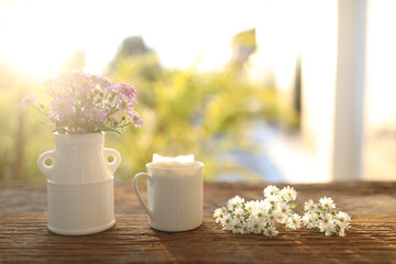 Fototapeta na wymiar Tea cup on aster flowers on wooden table and