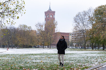 Young bearded male tourist with the Rotes Rathaus in the background and all snowed in.