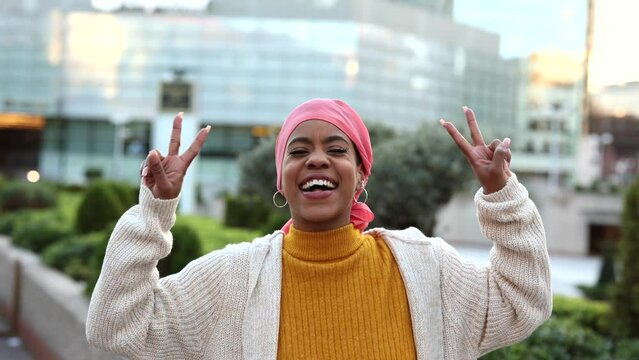video portrait of young woman with cancer, breast cancer survivor, african american with a pink handkerchief symbol of the fight against cancer