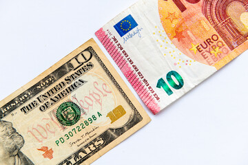 Fototapeta na wymiar A ten US Dollar bill and a ten Euro bank note isolated in white background.