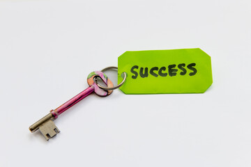 A key to success concept with a key and the word success isolated in white background.