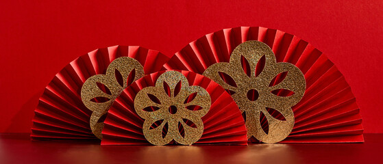 Happy Chinese New Year 2023 concept. Red paper fans with golden flowers on red background.