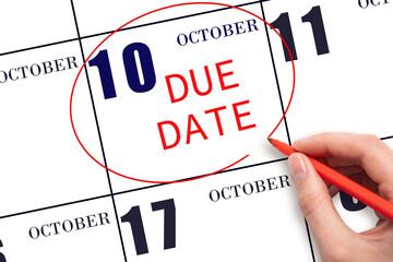 Hand writing text DUE DATE on calendar date October 10 and circling it. Payment due date