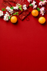 Happy Chinese New Year 2023 concept. Flat lay oranges, blossom flowers, money pockets on red...