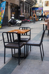 The table on the cast leg. Chairs with lather chair pads. Outdoor cafe.