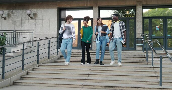 Group of diverse college students talking to each other and walking on campus