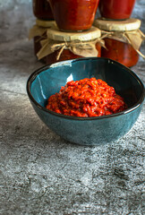A bowl of homemade lutenica and jars of the same