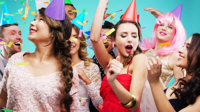 Birthday party, friends and dance celebration of people with fashion, comic and fun hats. Happy, music and dancing crowd together with confetti and club energy in a event or rave photobooth