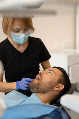 Young man at the dentist. Dentist woman. Dental office.