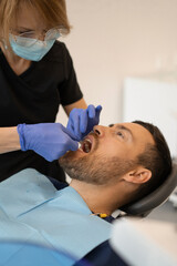Obraz na płótnie Canvas Young man at the dentist. Dentist woman. Dental office.