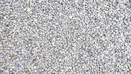 Granite gravel texture. Road surface made with small gravel. Textured gray pebbles. Crushed material background.