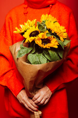 Bouquet of yellow sunflowers over a red background