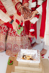 Indian newlyweds at wedding ceremony dressed in traditional costume having a ceremony with fire