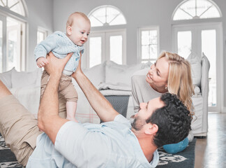 Obraz premium Relax, living room and parents playing with their baby together on the floor of their family home. Love, smile and happy mother and father bonding with their newborn child in the lounge of a house.