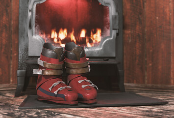 Vintage ski boots closeup in front of iron stove