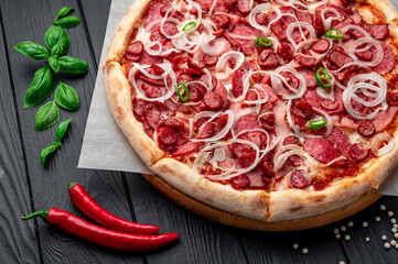 Spicy pizza with ham, sausage, jalapeno peppers and onions.