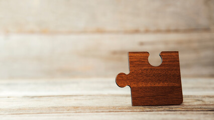 Brown pieces of puzzle stand on wooden table. Empty copy space for inscription or objects. idea, sign, symbol, concept of connecting