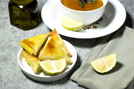 traditional bowl of spiced algerian vegetable soup named (Harira) and meat bourak named bourek and olive oil bottle 