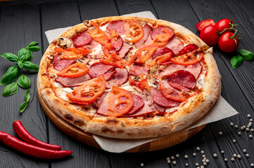 Italian pizza with ham, sausage, mushrooms, tomatoes and onions.
