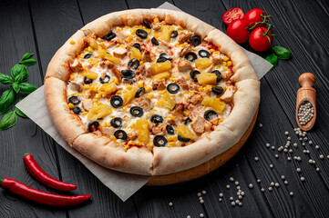 Delicious pizza with chicken meat, pineapple, corn and olives