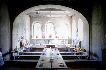 A dining room with covered tables in an ancient monastery with icons