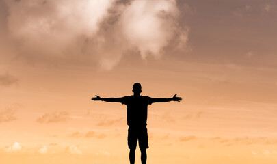 silhouette of man with outstretched arms. Feelings of joy and hope. 