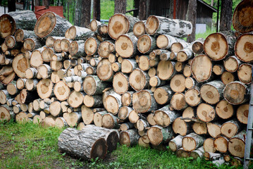 Large birch firewood and chocks lie in a stack and dry on a summer day