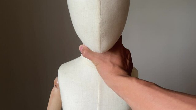 Creepy male hand grabbing child mannequin neck. Child abuse concept. Young children victim of domestic violence.
