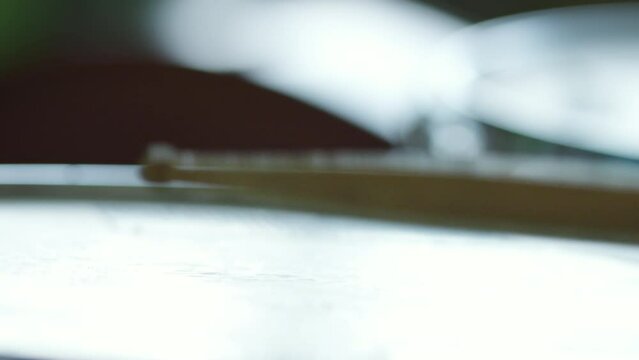 Close up impersonal shot of playing drum with drumsticks
