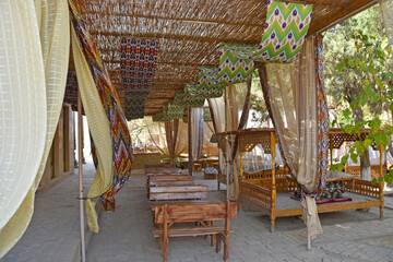 outdoor cafe with a wicker roof and oriental patterns in the old town of Khia in Uzbekistan