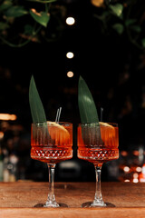 cocktail Aperol spritz in glasses. Cocktail aperol spritz decorated fresh orange slices, ice, greens and two black straw. Typical italian beverage, aperitif made with Prosecco sparkling white wine