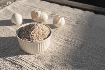Used crashed chicken eggshell used as a fertiliser for plants, flowers and tomatoes. Change from littering Into storage and processing, home made organic fertilizer. Nature background texture