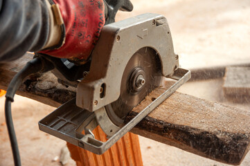 Mini circular electric saw in action. Cutting wooden boards to the required size.