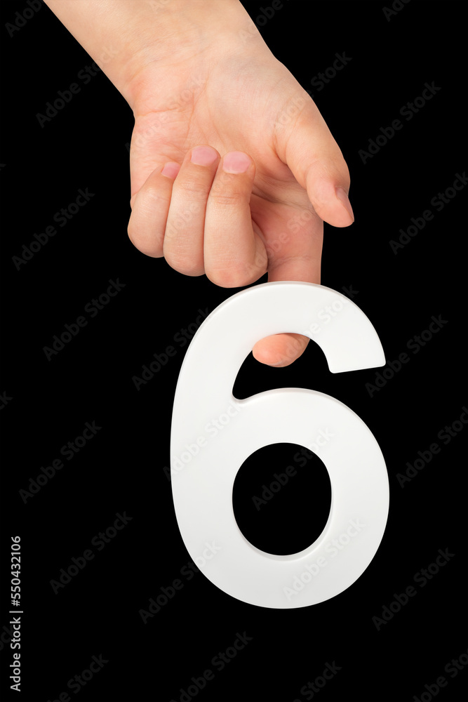 Poster number six in hand isolated on black background. number six in a child's hand holding on a black bac