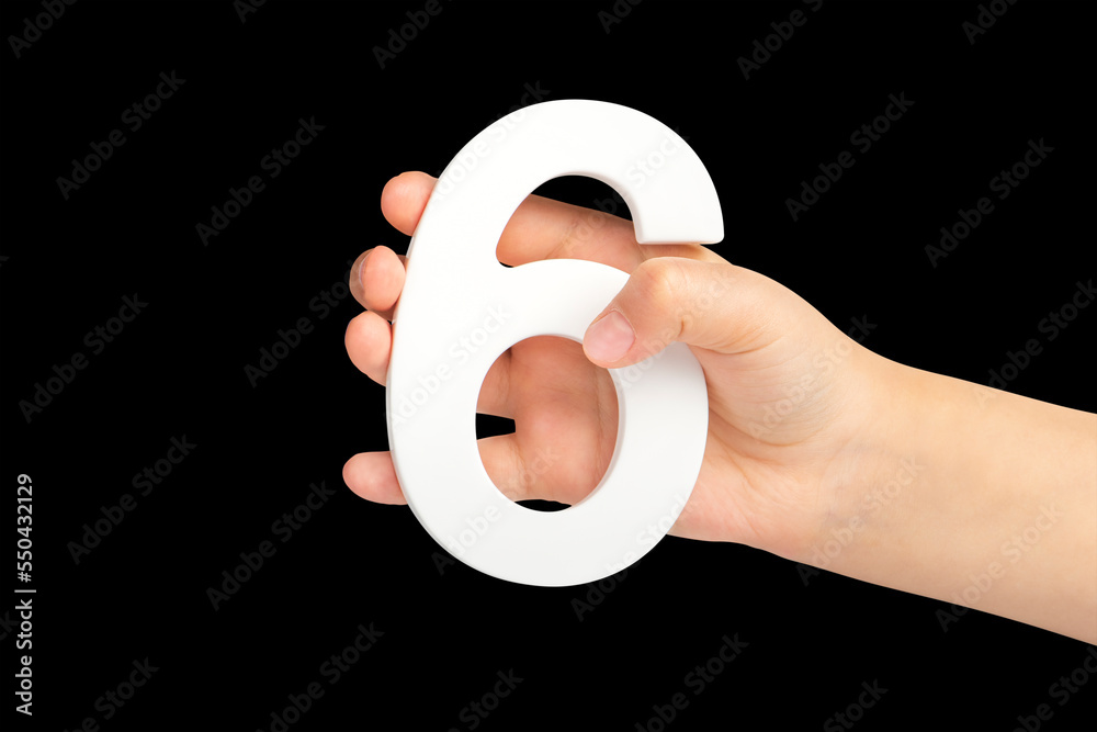 Poster number six in hand isolated on black background. number six in a child's hand holding on a black bac