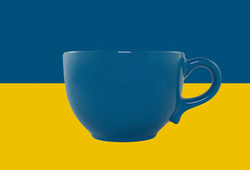 Empty decorative blue cup isolated on the background of the national flag of Ukraine. Close-up