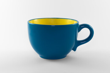 Empty decorative blue cup with one handle on a white background. For drinking tea, coffee, milk or water. Close-up