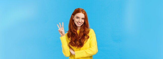 Gorgeous young redhead girl 20s in yellow sweater, smiling carefree making order, reservetion for...