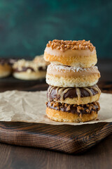 Close up of a stack of fresh homemade donuts with various toppings.