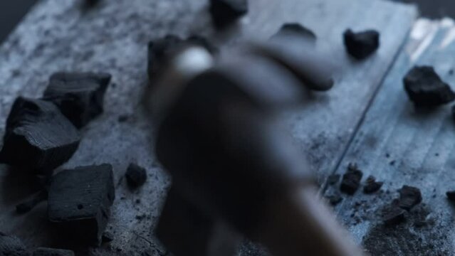 4k v&iacute;deo. Mano cogiendo un martillo de u&ntilde;a antiguo y viejo en el lugar de trabajo con carb&oacute;n