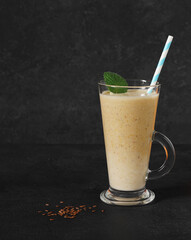 Fresh pumpkin and banana smoothies with linen seeds on dark background, copy space, vertical view