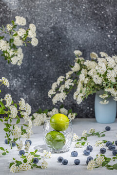 Two fresh limes in glass on light gray concrete table