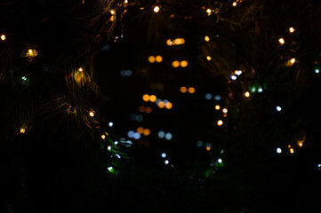 New Year 2023. Christmas beautiful lights bokeh on gold warm background. Defocused Lights on a Tree...