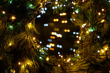 New Year 2023. Christmas beautiful lights bokeh on gold warm background. Defocused Lights on a Tree...