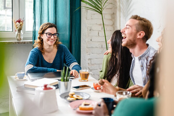 Happy woman smiling while her friends laughing, carefree moments of a young group of students in a cafeteria, breakfast and brunch time in a literary cafè