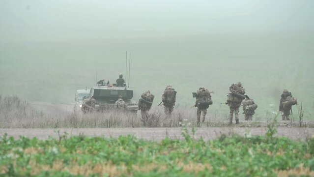 British army FV4034 Challenger ii 2 main battle tank passes an infantry troop unit on a 40kg loaded march tab military exercise, Wiltshire UK