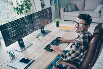Photo of positive cheerful programmer wear spectacles smiling web engineering indoors workplace...